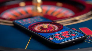 Um homem comemorando uma vitória em seu laptop enquanto símbolos de jogos flutuam ao redor, capturando a emoção dos jogos FIXE777.